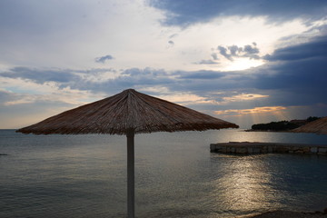Strandschirm an einem Strand bei Novigrad in Kroatien zur Abendstimmung