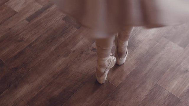 Ballet Dance. Ballerina in an airy beautiful elegant dress and in ballet slipper gently dances in an old interior studio with large windows. Natural lighting with haze.