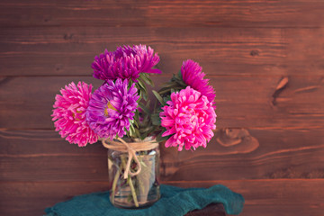 asters autumn bouquet of brightly colored wooden background