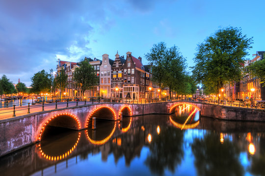 Beautiful cityscape of the famous canals of Amsterdam, the Netherlands, at night with bridges at the Emperor's canal (keizersgracht) and Leidse canal (Leidsegracht)