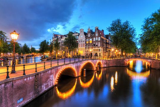 Beautiful cityscape of the famous canals of Amsterdam, the Netherlands, at night with bridges at the Emperor's canal (keizersgracht) and Leidse canal (Leidsegracht)