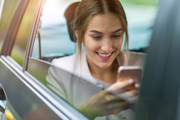 Woman with smart phone in a car
