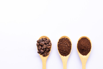 wooden spoons filled with coffee bean and crushed ground coffee on white background