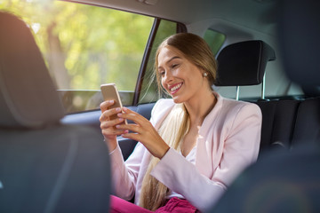 Woman with smart phone in a car
