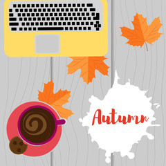 Autumn workplace. Laptop, coffee and yellow leaves on a wooden background