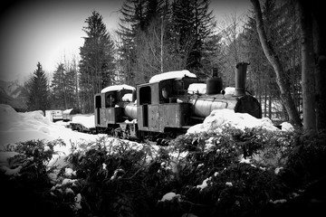 Old rusty steam locomotive in the open air in a parking lot in Chamonix. French Alps. Black and...