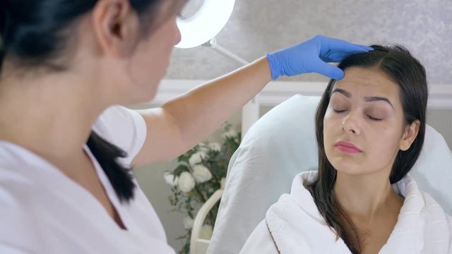 beautician consults woman about facial botox injection in the beauty salon closeup