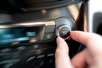 Obraz na płótnie Canvas Man turning on car air conditioning system