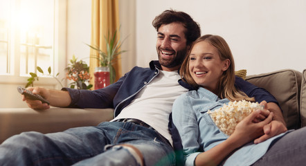 Couple watching TV on a sofa at home
