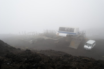Abandoned place and fog on the mount Etna, the big volcano in Sicily Italy. This was the former cablaway that carried up to the crater. Now there are structures and old cabines left full of rust