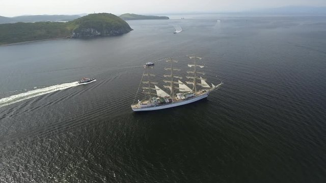 High altitude Large sailboat vessel sails frigate floating sea. Seascape nature islands. Ocean Cruise Swimming Sports. Speed-boat. Unique journey tourism around world. Summer sunny day. Aerial Drone
