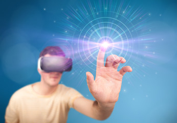 Young impressed man wearing virtual reality goggles with blue circles around his finger 