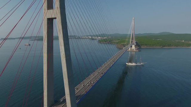 Unique Drone near Russian Cable bridge road traffic. Large sails Ship sailboat vessel frigate navy. Close cable pylon. Vladivostok Russia cityscape Eastern Bosphorus. Travel romantic landmark. Aerial