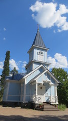 Blue christian church in russian village on a sunny summer day
