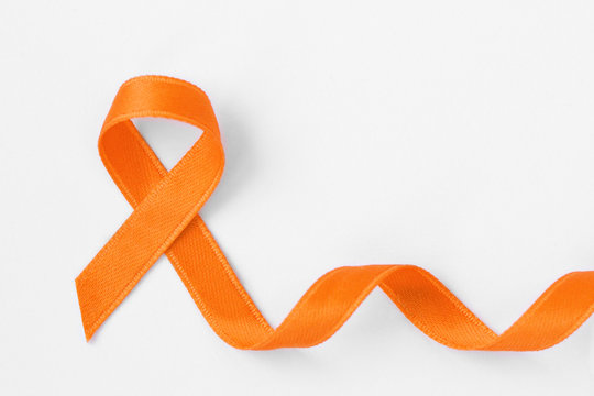 Orange ribbon on white background - Concept of leukemia awareness, kidney cancer association, multiple sclerosis and animal abuse