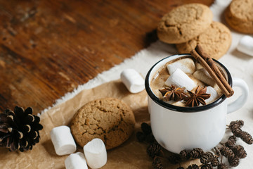 Winter and autumn hot drink. Hot chocolate or cocoa with marshmallow , cookies and spices on white and wooden background.