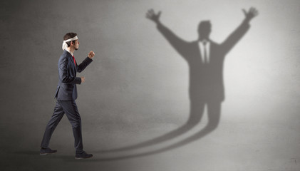 Businessman with boxing gloves fighting with disarmed businessman shadow
