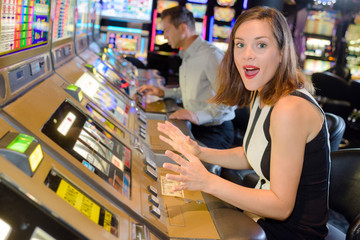 Woman playing arcade machine, surprised expression