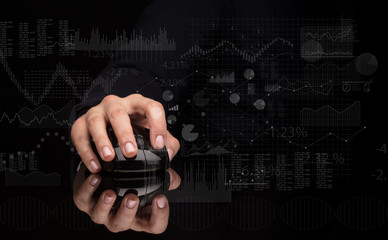 Obraz na płótnie Canvas Hand using wireless mouse with financial concept on dark background 