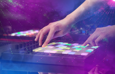 Hand mixing music on midi controller with party club colors around 