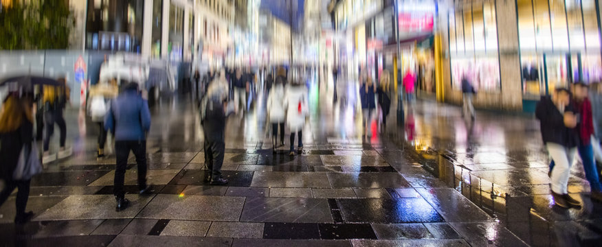 silhouette of colorful people on the rainy night street