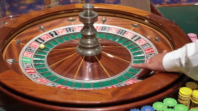 a casino dealer spins roulette hand