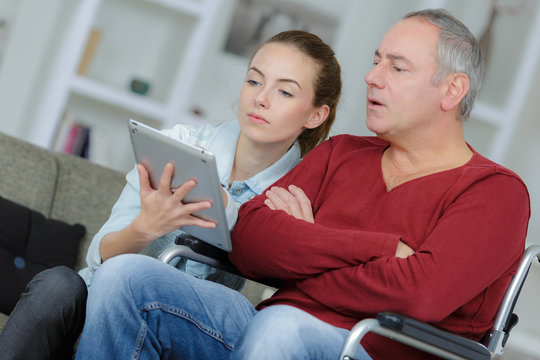 young woman trying father to use tablet