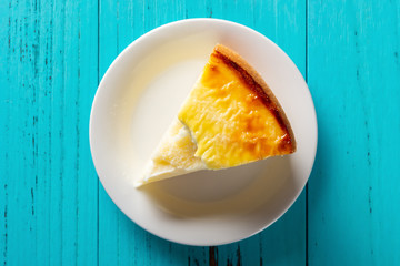 top view studio shoot of home made cheese cake on a blue table with a bite
