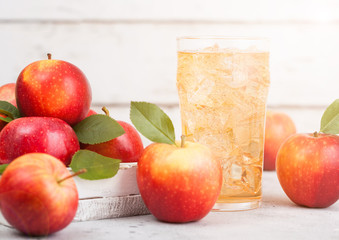 Glass of homemade organic apple cider with fresh apples in box on wooden background with sun light