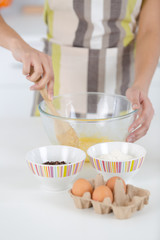 cracking an egg into a bowl preparing dough for baking