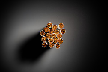 bunch of cigarette in dark with a spot light