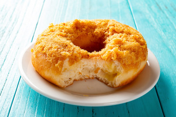side view studio shoot of donut with shredded pork on top with a bite