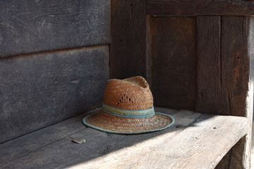 Sombrero de paja sobre un banco antiguo de madera
