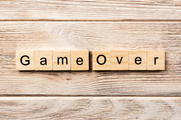 game over word written on wood block. game over text on table, concept