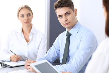 Fototapeta premium Group of business people or lawyers discussing terms of transaction in office. Meeting and teamwork concept