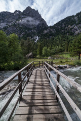 Fototapeta premium Wood bridge in the middle of the Mello Valley in Lombardy (Val di mello Sondrio).