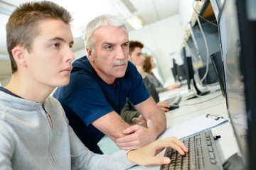 teacher and a student with a computer
