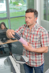 Man at photocopier holding package