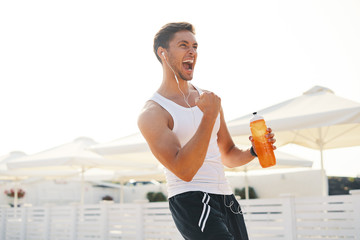Athletic muscular man feeling victory and enjoys success