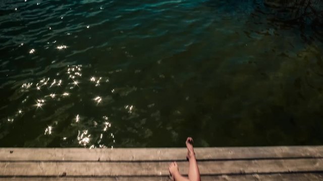 Young woman sun tanning on a dock and reveal shot of Worthersee lake, Austria, vintage film camera 