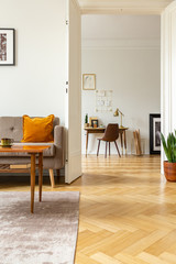 View from the living room with herringbone parquet floor into a home office interior with golden...