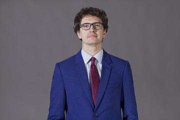 Young man wearing in blue suit and glasses smiling
