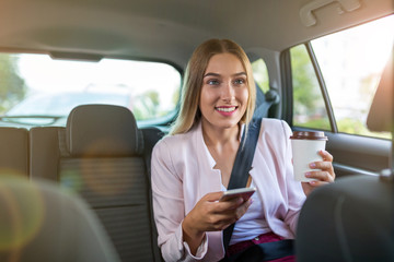 Woman with smart phone in a car
