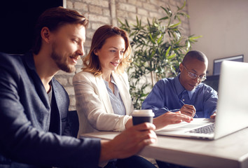 Business people working at desk on laptop.