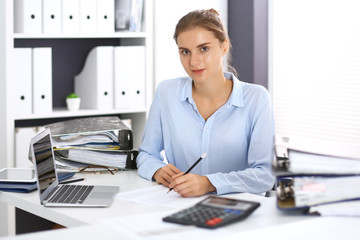 Woman bookkeeper or financial inspector calculating or checking balance, making report. Internal...