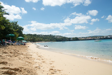 White sand beach, blue sky, green palm trees