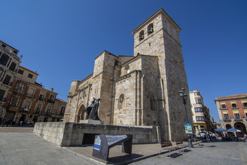 Fototapeta na wymiar Iglesia románica de San Juan Bautista en la Plaza Mayor de Zamora con la estatua del Merlu 