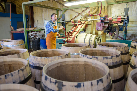 Cooper in background of barrel making factory