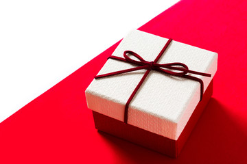 White gift box on red and white background. Copyspace
