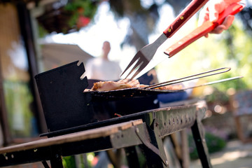 Grilling food on barbecue grill, hands preparing skewers